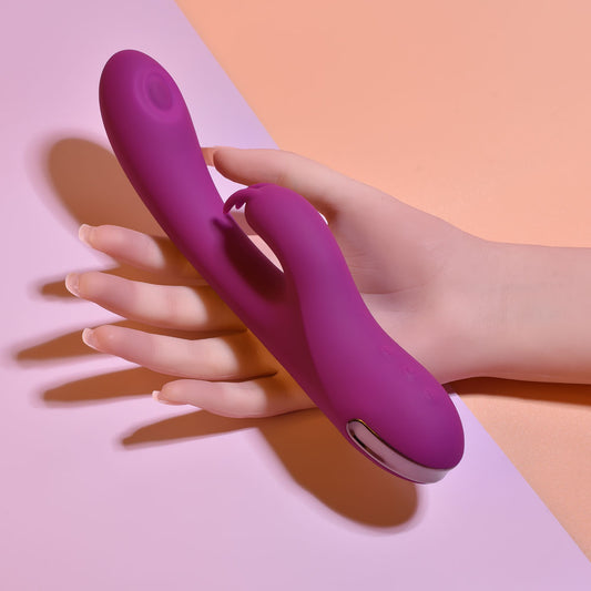 Hand holding a purple electronic device against a pink and orange background