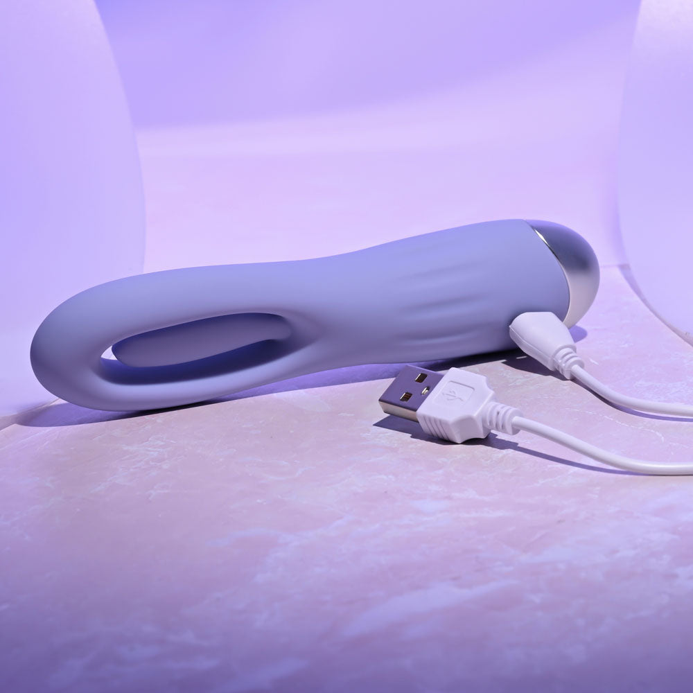 White electronic device with USB cable on a light purple surface