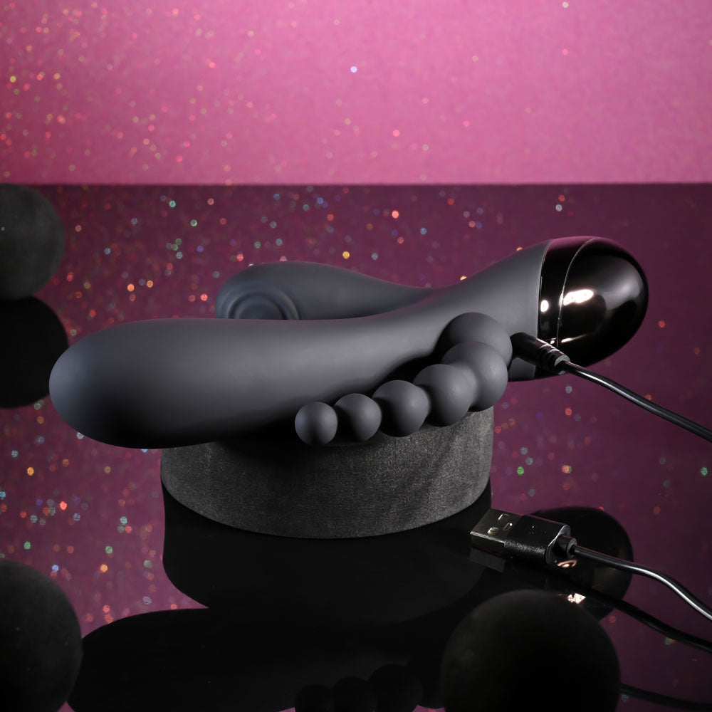Gray foot-shaped device with a USB connection on a reflective surface against a purple gradient background.