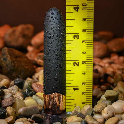 Black cylindrical object with water droplets on a yellow measuring tape against a rocky background
