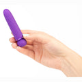 Hand holding a purple cylindrical object against a white background