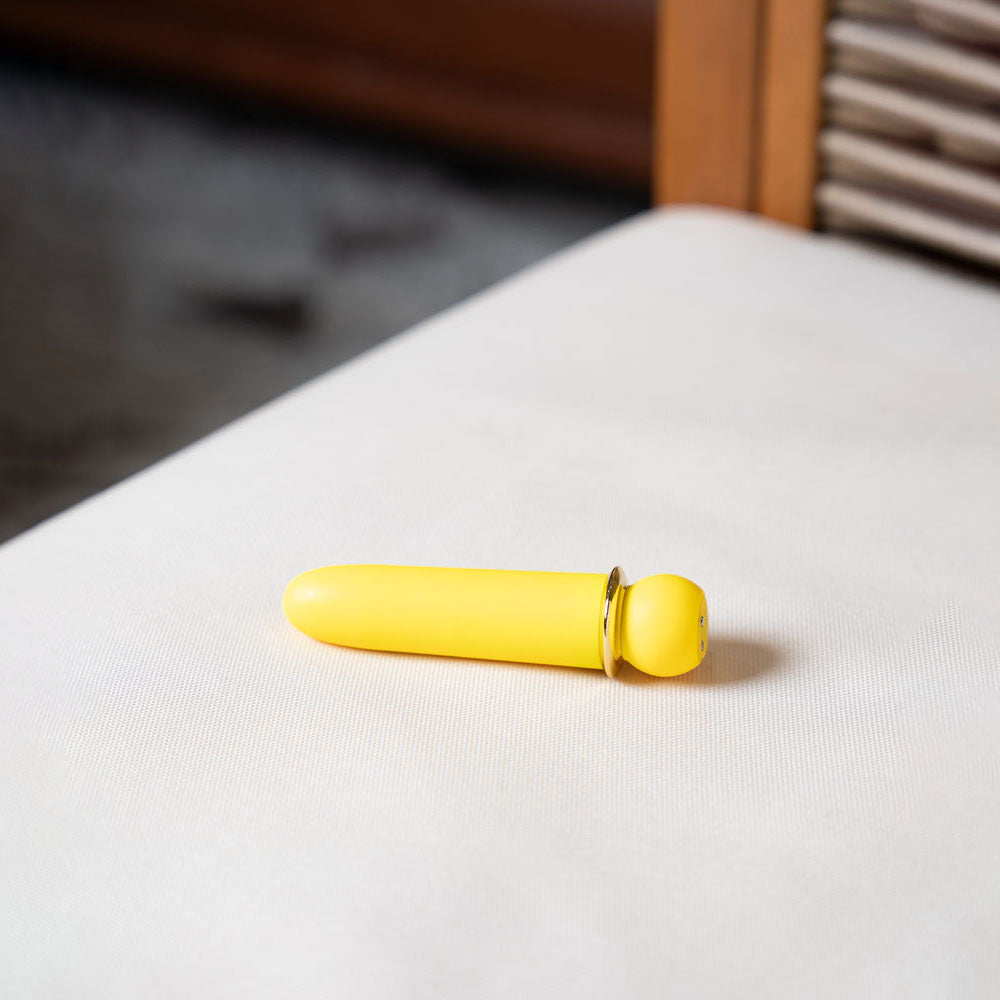 Yellow object on a white surface with a blurred background