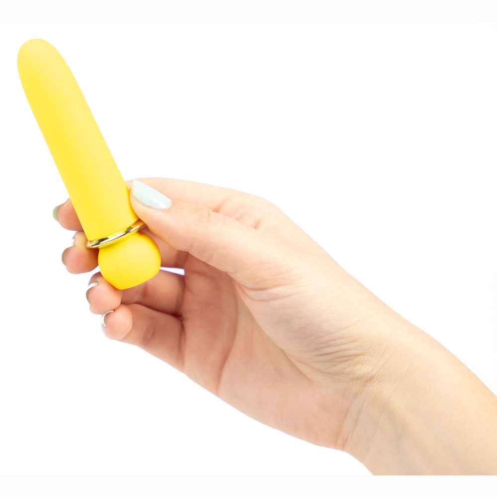 Hand holding a yellow tool against a white background