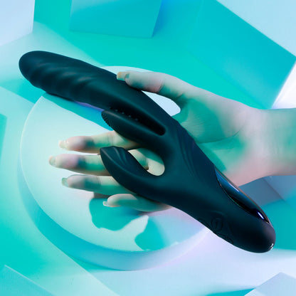 Black handheld massager held by a hand against a teal geometric background