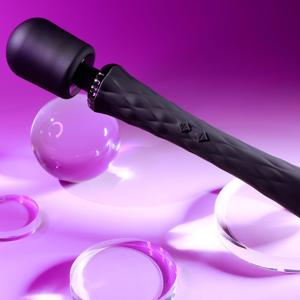 Black massage roller with purple accents on a matching purple background