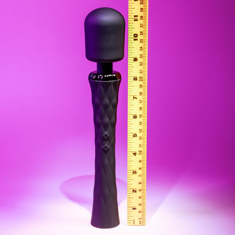 Black textured handheld device with a measuring tape for scale on a purple background