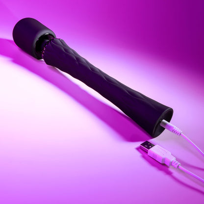 Black handheld device with a USB cable on a purple background
