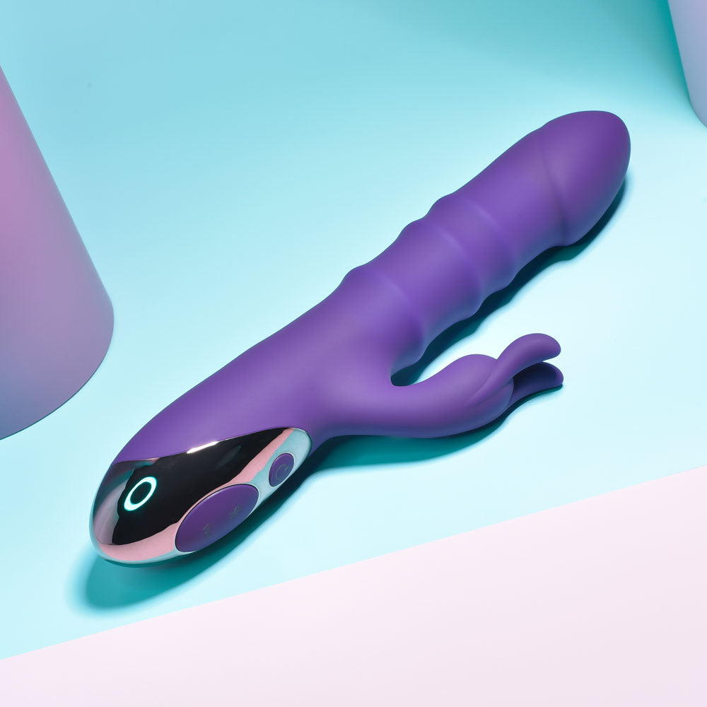 Purple and black electronic device on a light blue and pink gradient background
