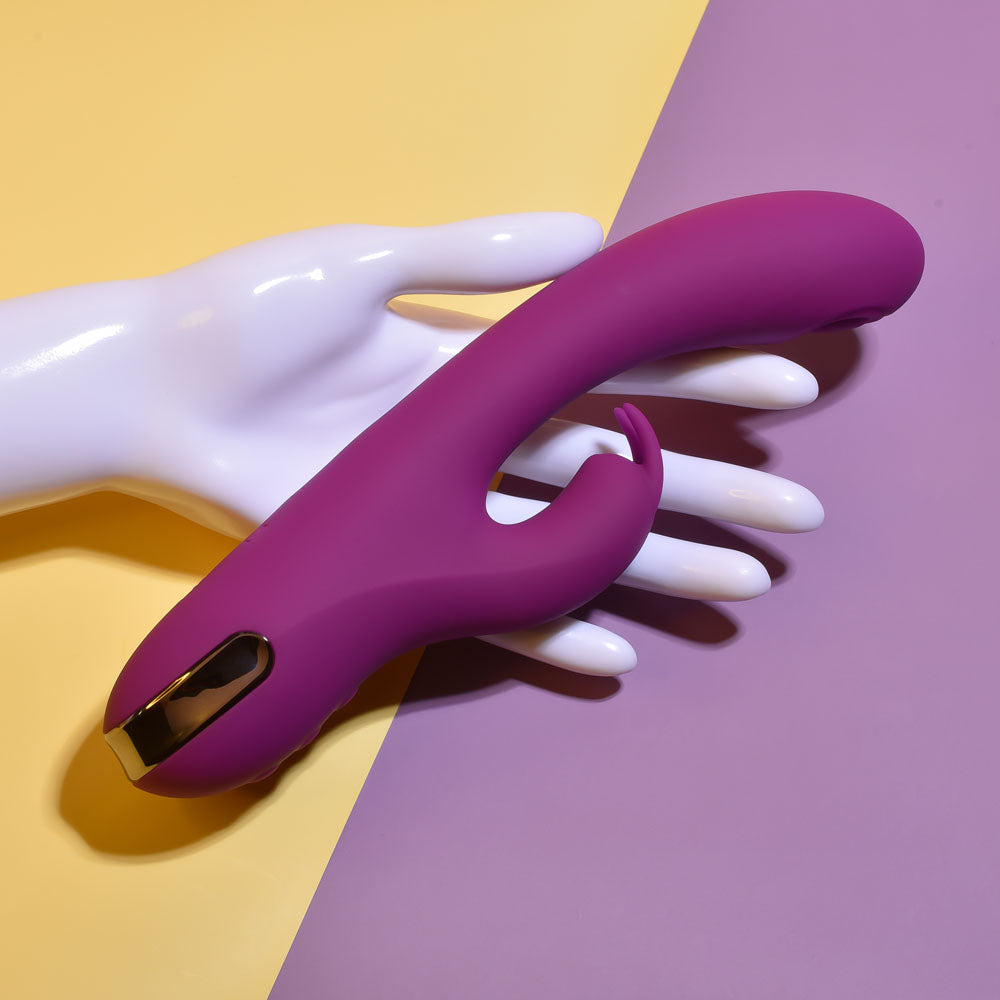 Purple and gold device on a white hand against a yellow and purple background