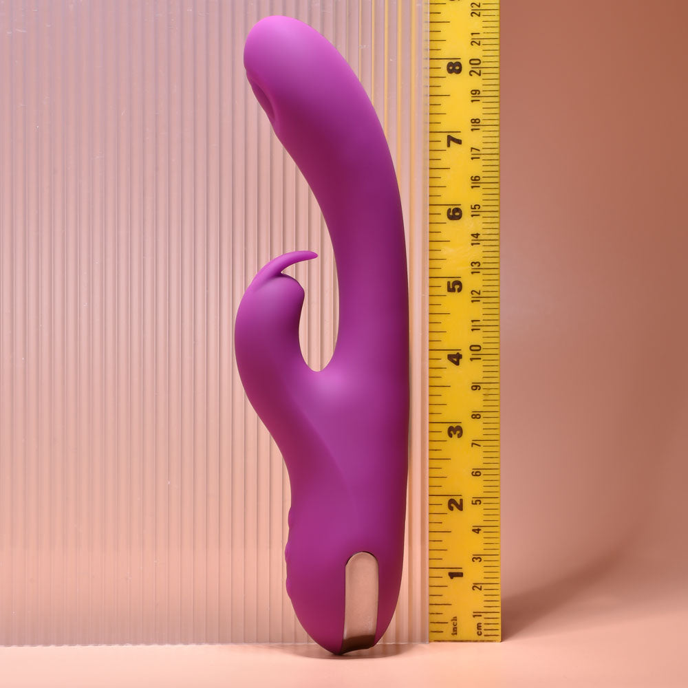 Purple tool or device next to a yellow measuring tape on a pink background