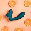 Teal silicone sleeve on a pink background with sliced oranges.