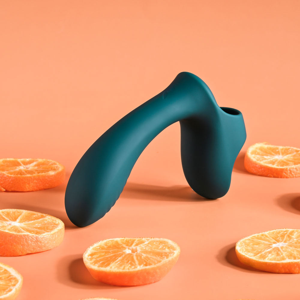 Blue ergonomic object on a peach background with sliced oranges