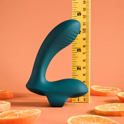 Teal silicone product with a measuring tape and orange slices on a peach background