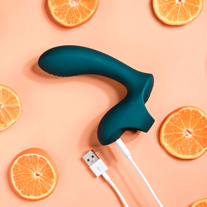 Blue handheld device with USB cable surrounded by sliced oranges on a peach background