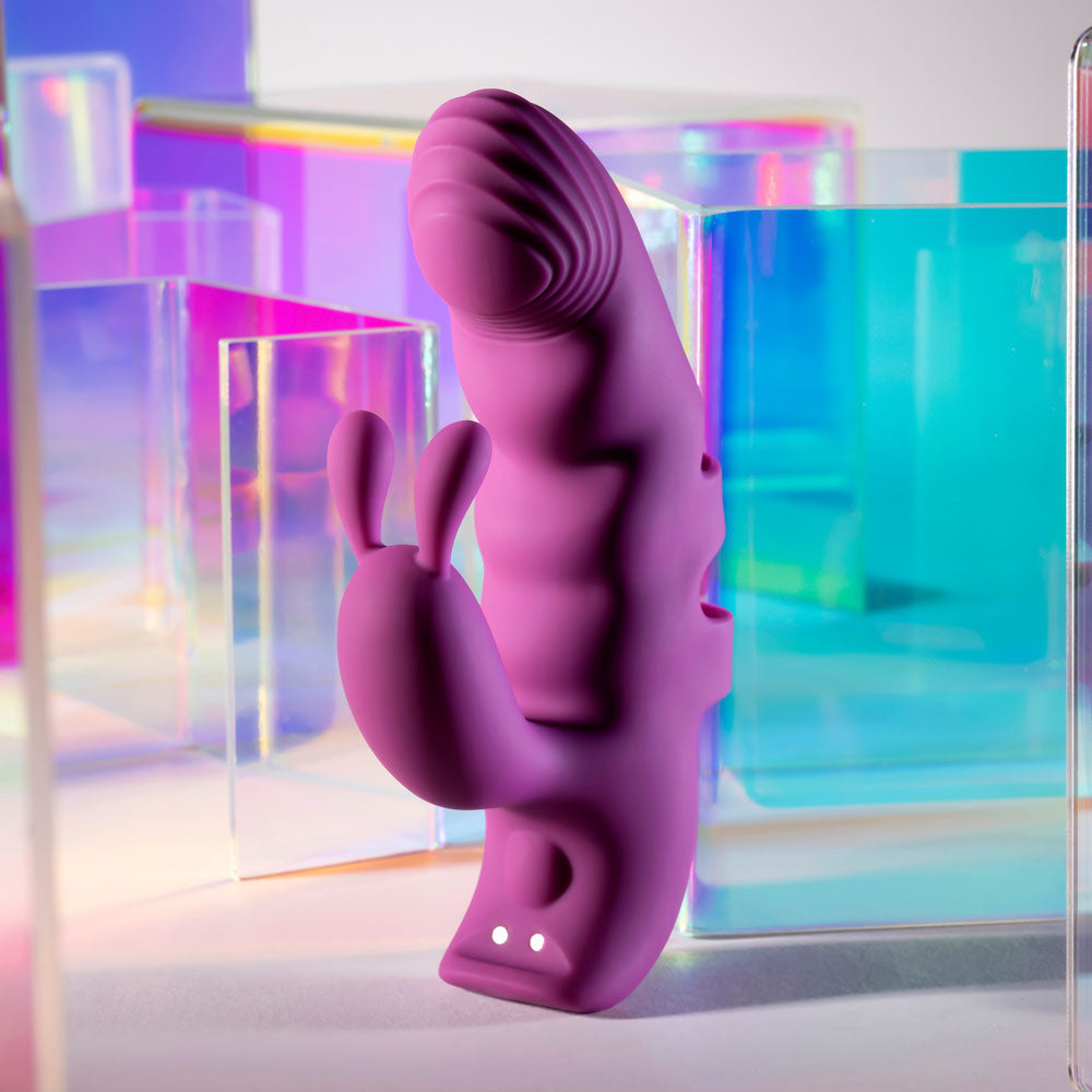 Purple silicone product with abstract design against a colorful geometric background