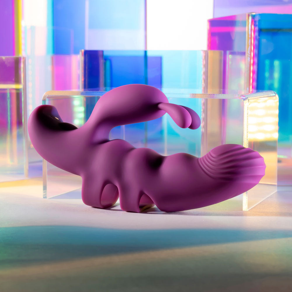 Purple abstract sculpture against a colorful, geometric background