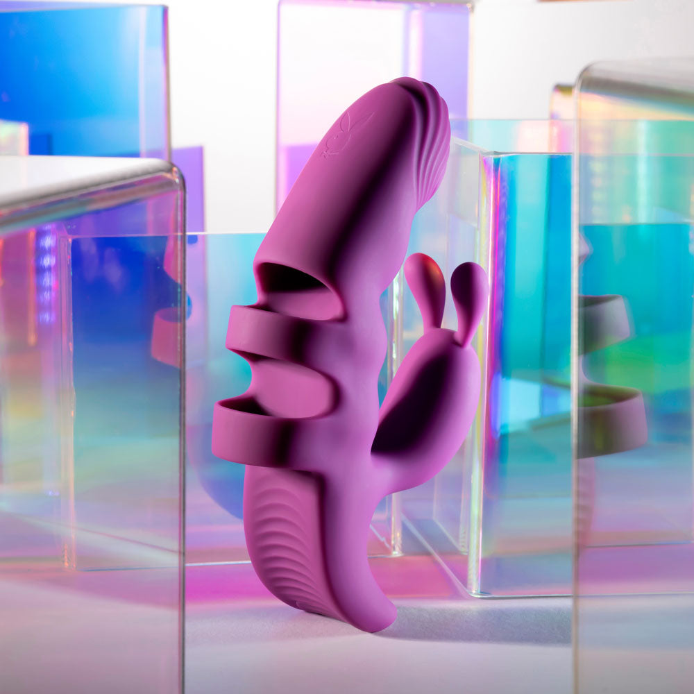 Purple abstract sculpture against a colorful geometric background