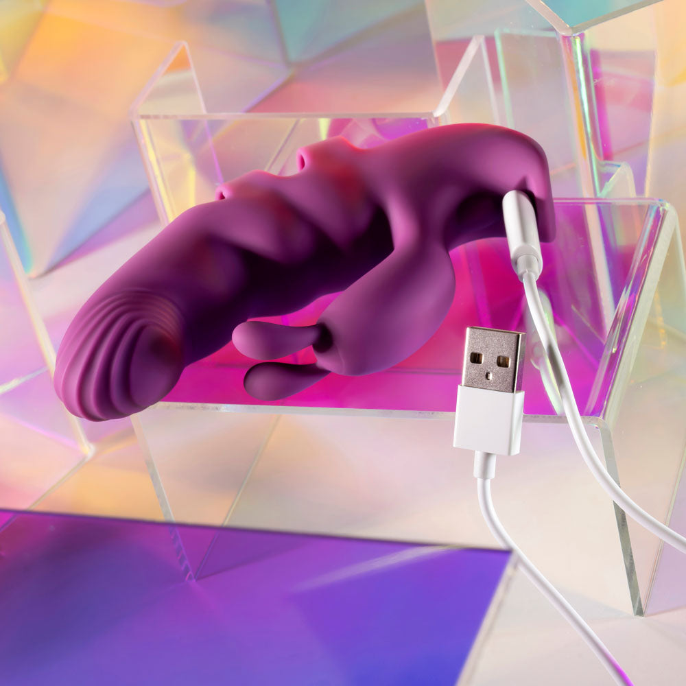 Purple phone receiver with USB cable on a colorful geometric background