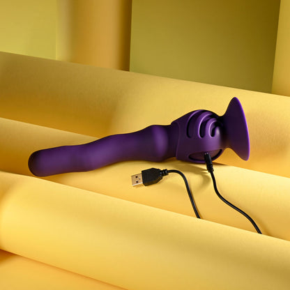 Purple electronic device with USB cable on a yellow fabric background