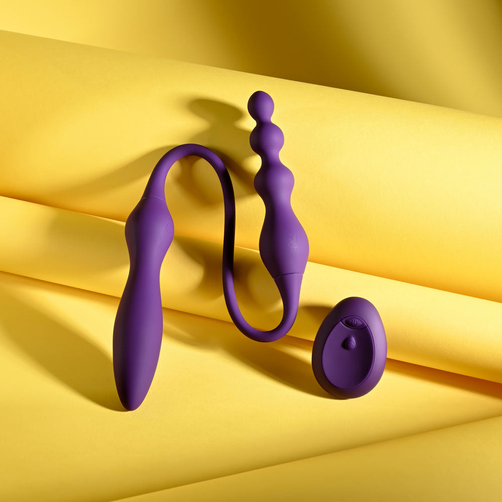 Purple silicone butt plug on a yellow fabric background