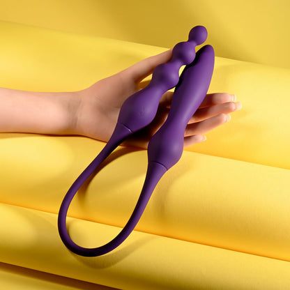 Purple silicone tool held by a hand on a yellow background