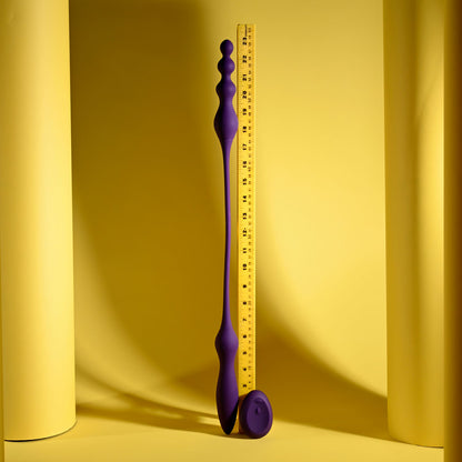 Purple measuring tool with a ruler on a yellow background