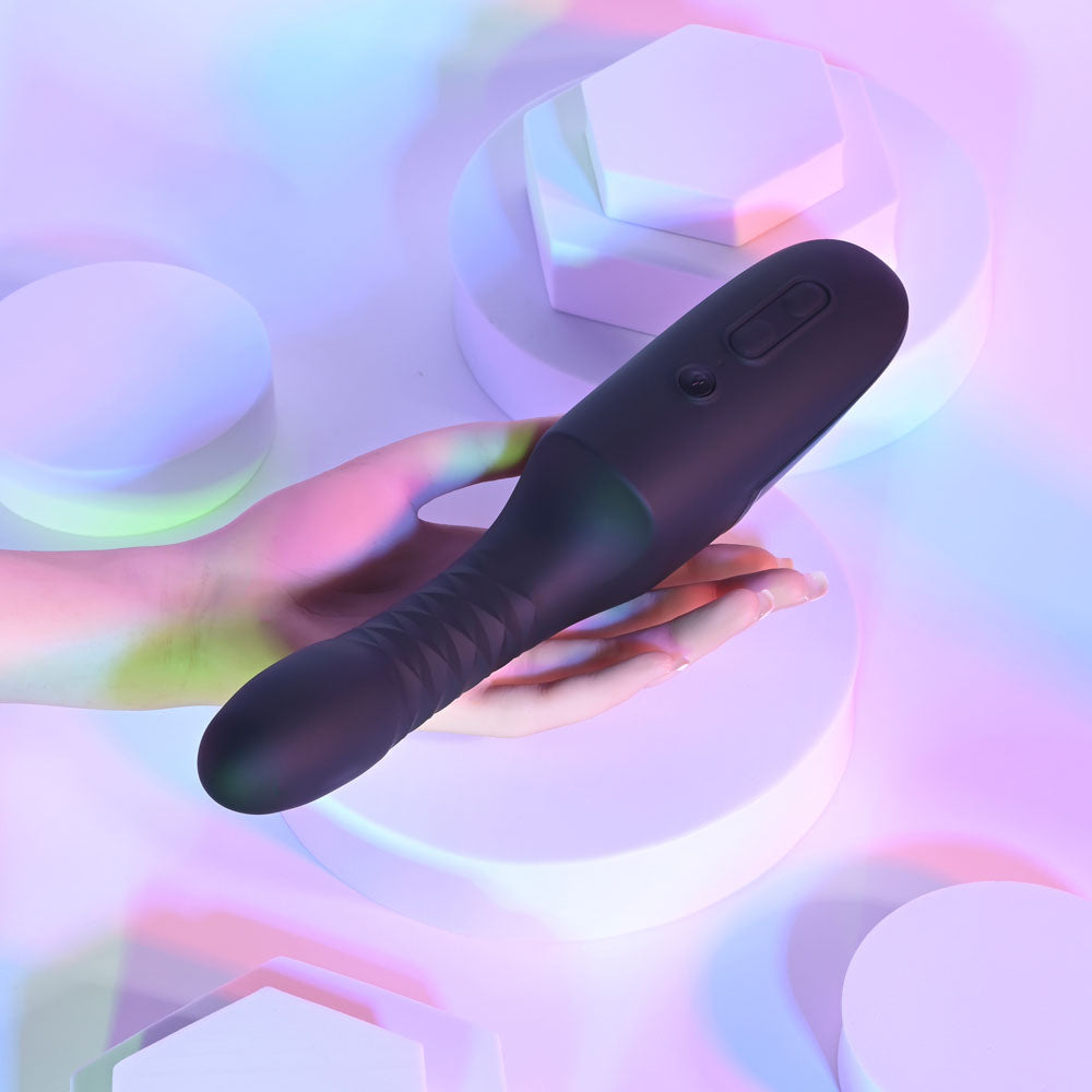 Black electronic device held in a hand against a colorful, abstract background