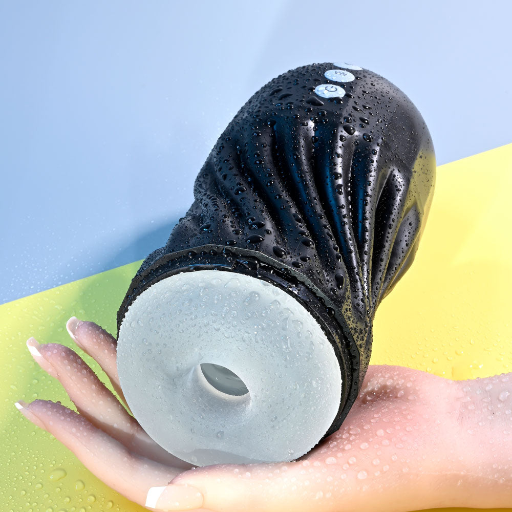 Black and white shower head held in a hand with a blue background