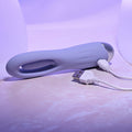 White electronic device with USB cable on a light purple surface