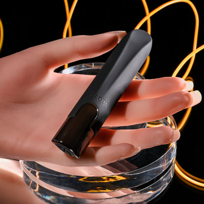 Hand holding a black vape device over a glass with a dark background and glowing orange elements.