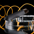 Black electronic device on a clear stand with glowing yellow circles in the background