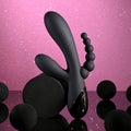 Black abstract sculpture on a pink reflective surface