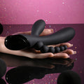 Black flexible tool held in hands against a pink and purple gradient background