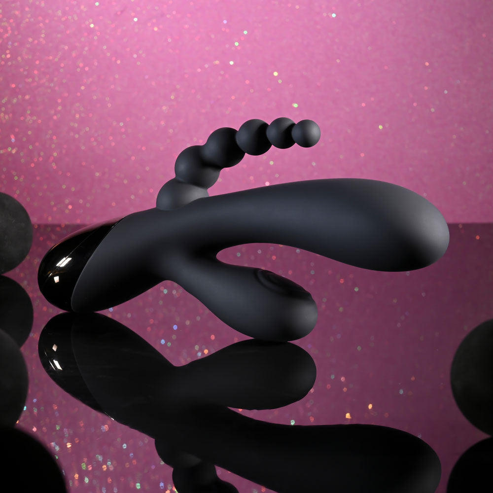 Black spiral object on a pink glittery background