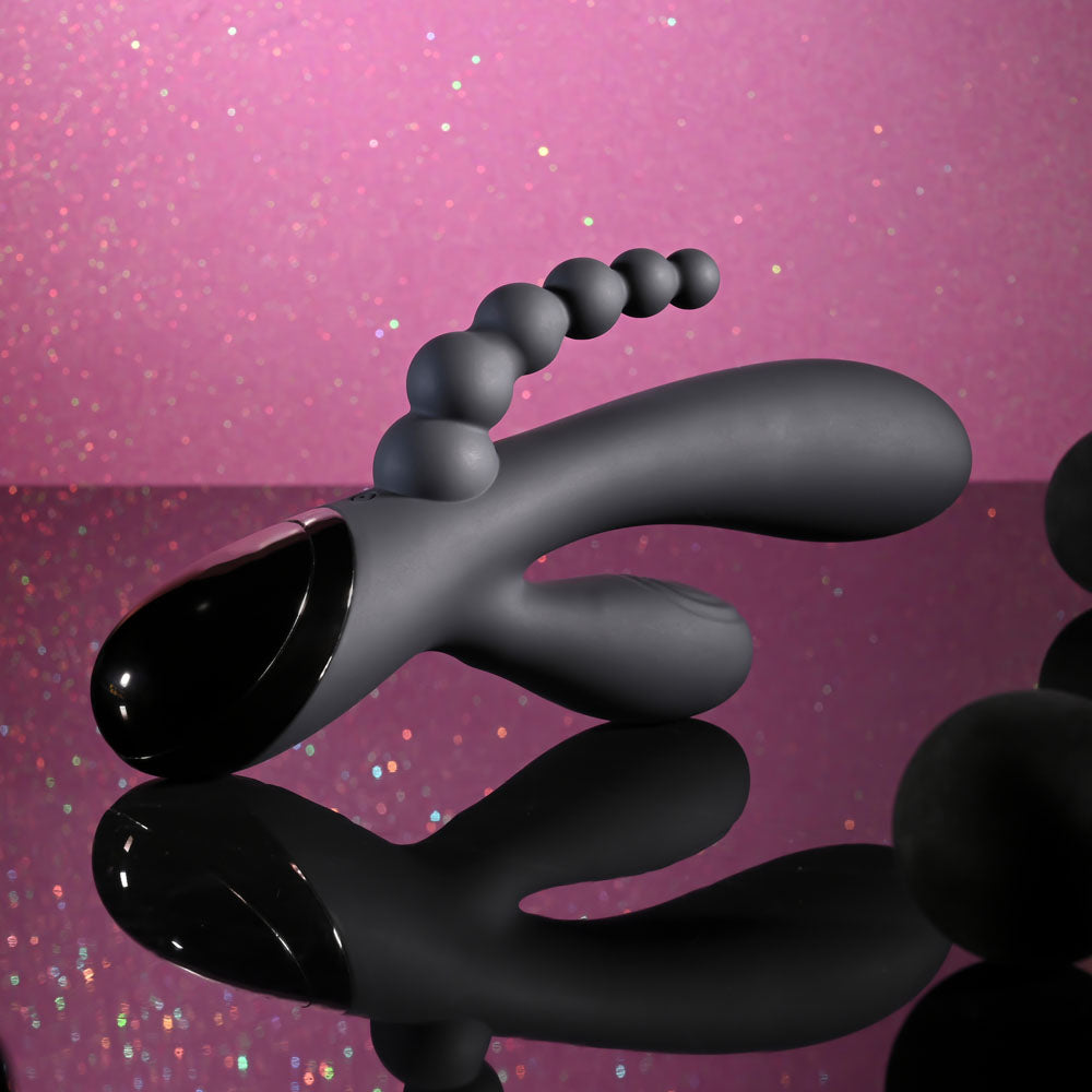 Black and gray object on a pink glittery background