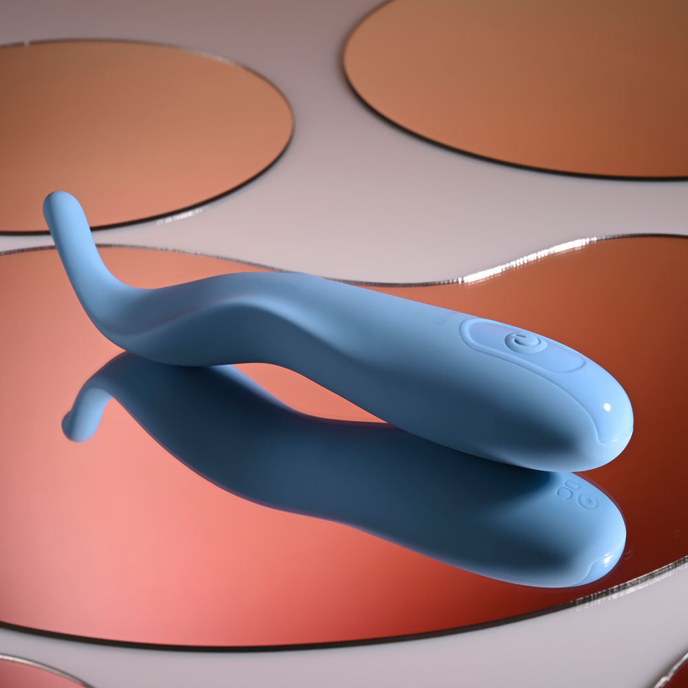 Blue electronic device on a reflective surface with a colorful background