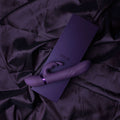 Hand holding a purple 'VIVE' box on dark fabric
