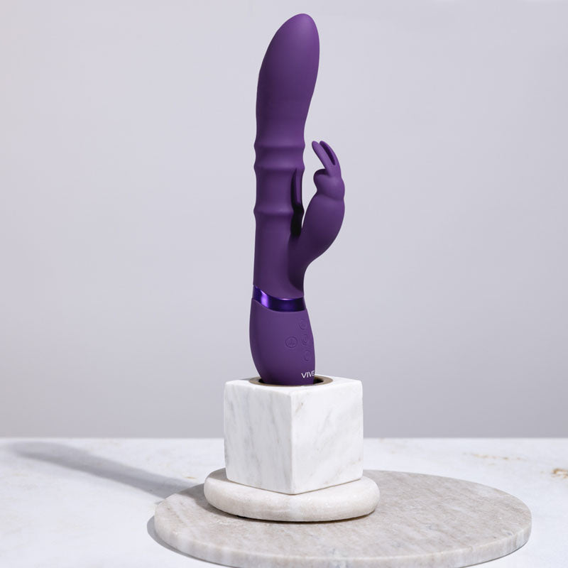 Purple toy on a marble stand against a light gray background